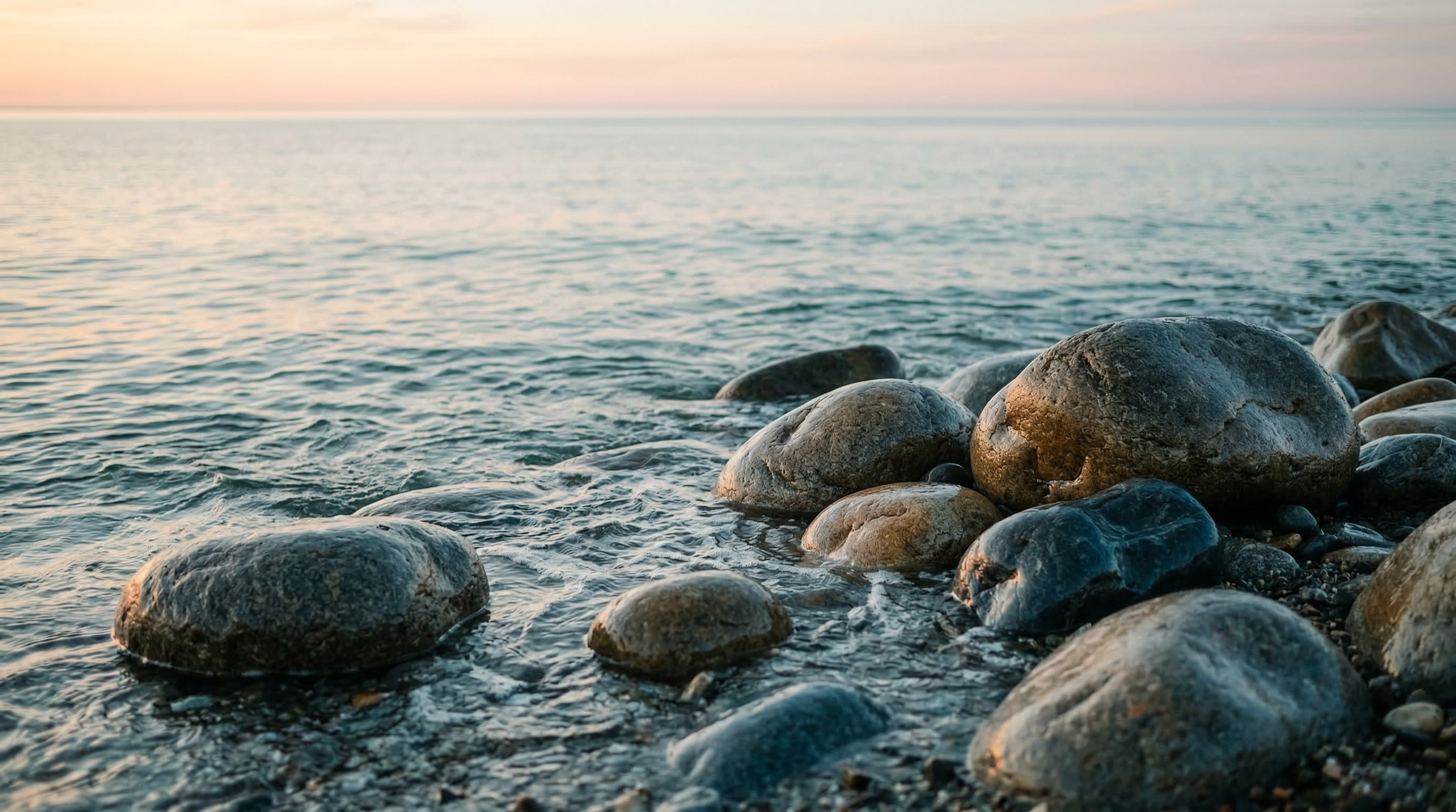 Smooth ocean rocks with calm water at sunrise
